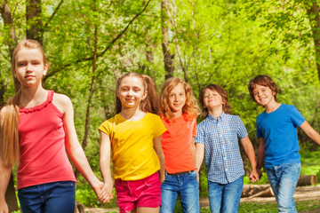 Happy friends walking together in the summer park