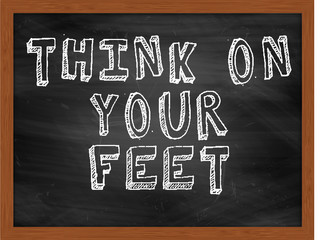 THINK ON YOUR FEET handwritten text on black chalkboard