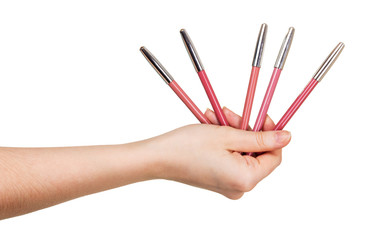 Pencils for use lip line in female hands isolated.