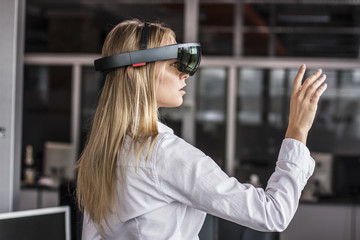 Virtual reality device. Woman playing game in virtual reality glasses. Headset  with virtual screen. Girl touch something using modern glasses with virtual screen. 