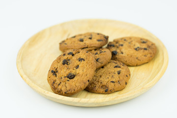 Chocolate chip cookie in wood dish on white