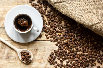 coffee beans with coffe cup on wooden table top view