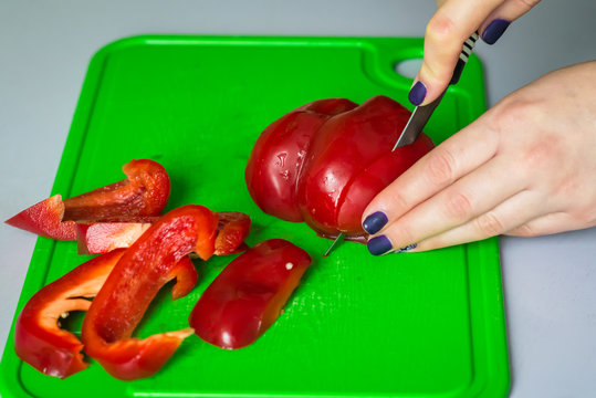 Hand Cut Red Bell Pepper On A Gold Board