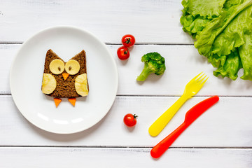 children's breakfast owl shaped sandwich with vegetables and fruits