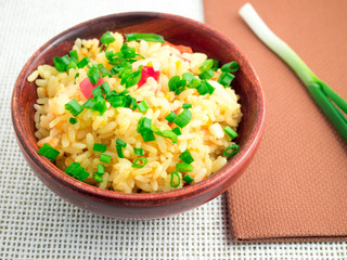 Small wooden bowl of cooked rice and leek