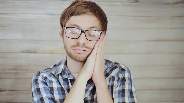 Portrait of young man in glasses sleeping and dreaming. Sleep sign