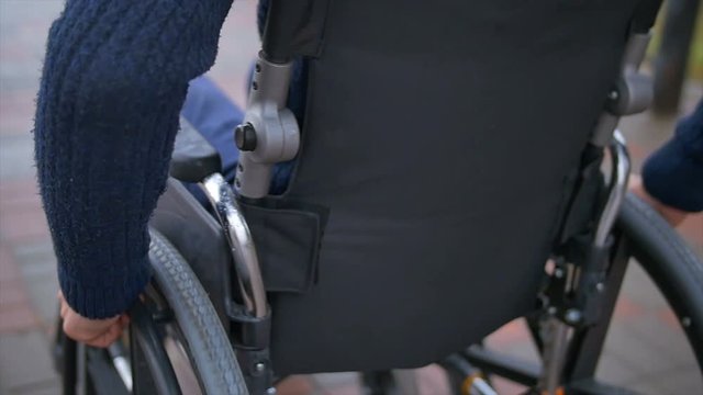 The man ride a wheelchair. Slow motion