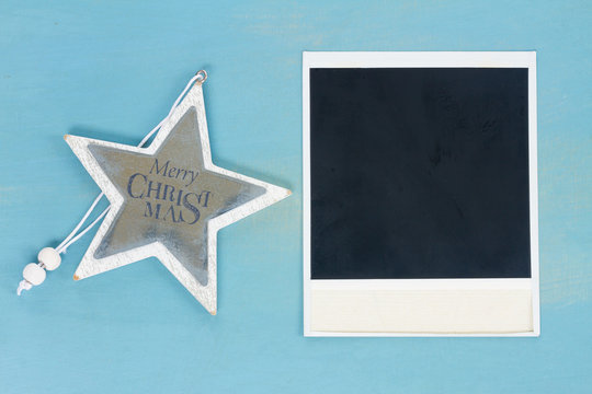 Blue and white christmas with star and instant photo on blue wooden background