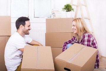 Young couple moving in to new home together. Home, people, moving and real estate concept