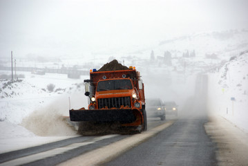 Snowplow sanding winter road