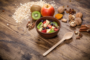 oatmeal in bowl and fruits on wooden table