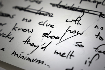 Lyrics written on paper in black ink close up. Focus on the word "school"