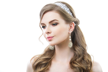 Beautiful woman with long curly hair. On her white earrings and headband. Pink lips and golden eyelids makeup.