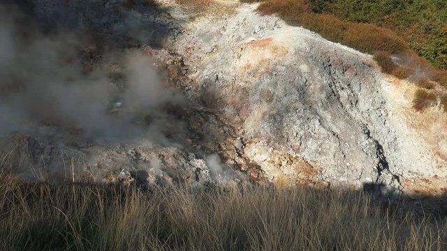 Steam from a fumarole in a ridge of a geothermal valley
