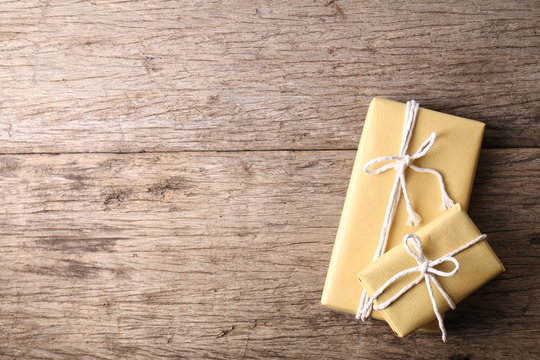 Presents in brown paper wrapping on wooden surface
