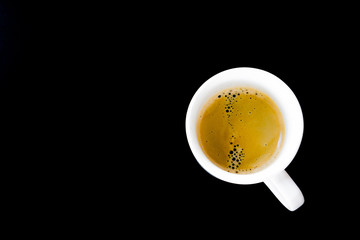 A cup of hot coffee in white mug on black background