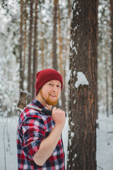 bearded man with an hatchet in the winter forest