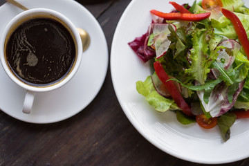 Lettuce leaves the seasoned with oil and two black coffee. Lunch.