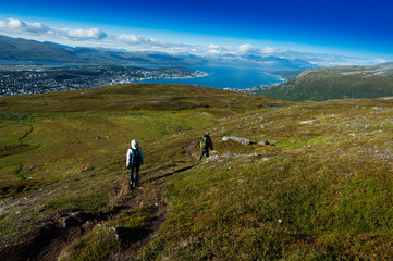 Couple descending from Norway mountain background