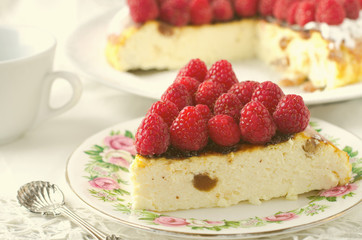 Cheesecake, souffle, cream mousse, pudding dessert with fresh raspberries and mint leaves on a white plate