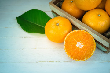 Fresh whole orange fruits and sliced orange on  wood background
