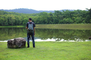 Man and reflection on lake at Chet Khot waterfall ,Thailand