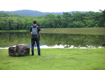 Man and reflection on lake at Chet Khot waterfall ,Thailand
