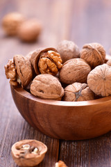 Walnuts in wooden bowl on table with Nutcracker.