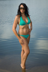 Obraz premium Beautiful woman in bikini on the beach by the lake