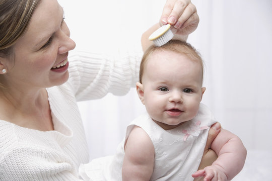 Mother brushing baby's hair