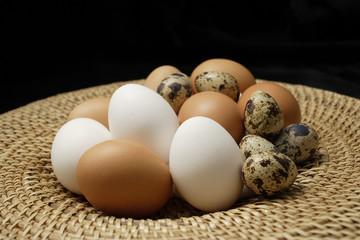 Basket of brown eggs, white eggs, quail eggs