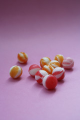 unwrapped hard candies on pink paper