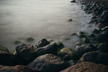 Stony sea coast with smooth waves