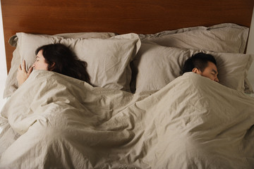 Man and woman sleeping in bed together