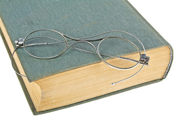 Old book and old glasses isolated on white background