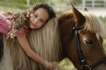 Young girl hugging pony