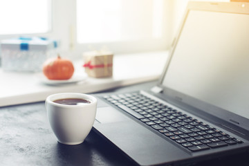 Coffee cup next to the laptop