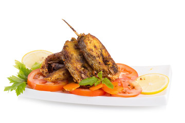 Fried fish in a plate with ingredients