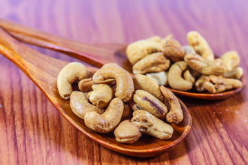 Cashew nuts on a wooden spoon.