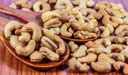 Cashew nuts on a wooden spoon.