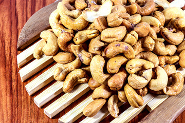 Cashew nuts on a wooden spoon.