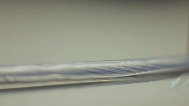 Work with fiber optic cable / Male hands cut off unnecessary insulation from cable and remove screen braid during preparing to installation.