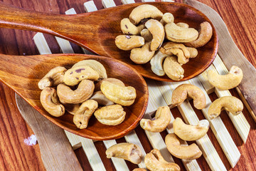 Cashew nuts on a wooden spoon.