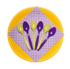 Colorful disposable plates, plastic spoons and doily isolated on white.