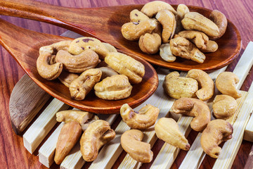 Cashew nuts on a wooden spoon.