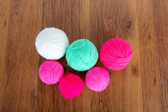 Bright balls of acrylic yarn on a wooden table. Needlework. Knit and Crochet. Fashion trends.