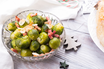 Brussels sprouts with fried bacon and almonds. Delicious Christmas themed dinner table. Holiday concept.
