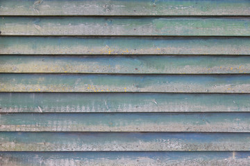 part of shed wall consisting of old wooden planks with faded gre