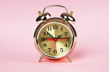 golden alarm clock on a color background