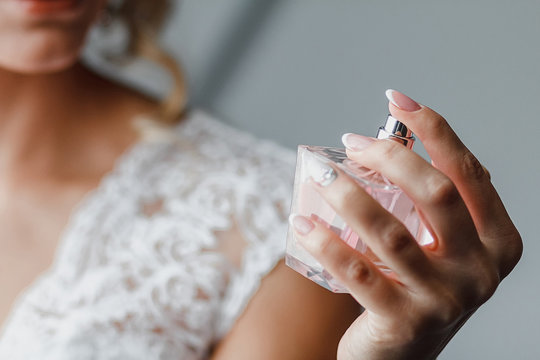 Elegant bride holding in hands a bottle of luxury perfume - Powered by Adobe